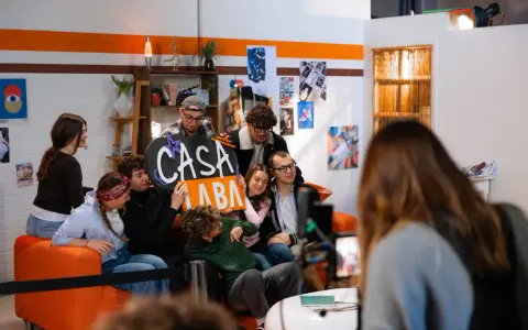 A group of young people pose for a photo, holding a sign that says "CASA LABA".
