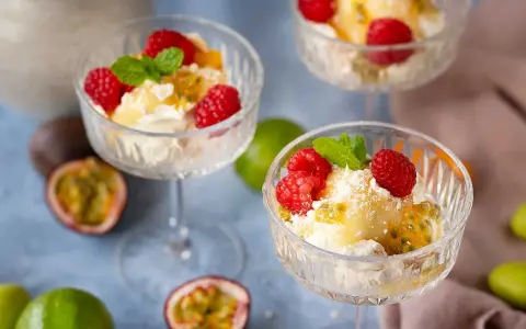 En härlig påskdessert i glas med grädde, passionsfrukt, hallon och mynta. Perfekt för påskfirandet!