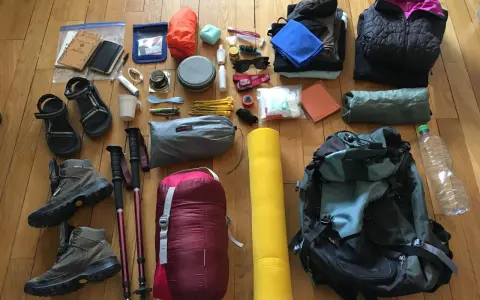 Préparatifs pour une randonnée : chaussures, bâtons, sac de couchage, sac à dos, vêtements, trousse de toilette, gourde. Voici comment ranger son sac de randonnée.