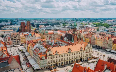 Wrocław słynie z kolorowych kamienic na Rynku i wież kościelnych. Widok z lotu ptaka na tętniące życiem miasto.