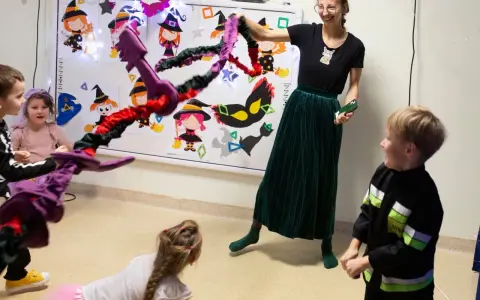 Wesołe zabawy integracyjne z czarownicami i magicznymi kluczami. Dzieci i nauczycielka bawią się w Halloweenowe gry.