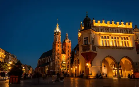 Wieczorny spacer po Rynku Głównym w Krakowie. Sukiennice i Kościół Mariacki oświetlone, tworzą magiczną atmosferę na udany weekend w Krakowie.