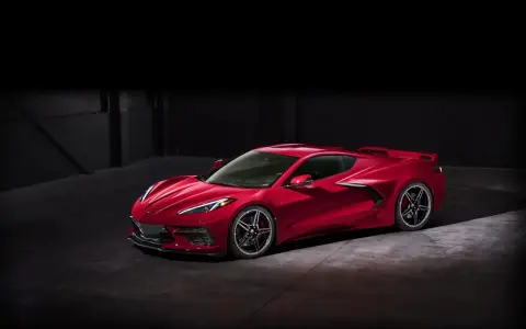 Czerwony Chevrolet Corvette C8 w ciemnym pomieszczeniu. Marzysz o tym aucie? Sprawdź corvette c8 cena i spełnij marzenie!
