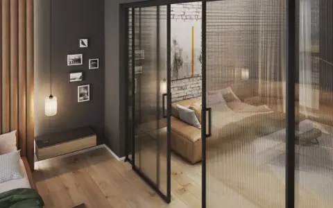 Nowoczesne rozwiązanie jak pogodzić salon z sypialnią: szklana, przesuwana ściana z salonu oddziela przytulną sypialnię z kanapą i łóżkiem.