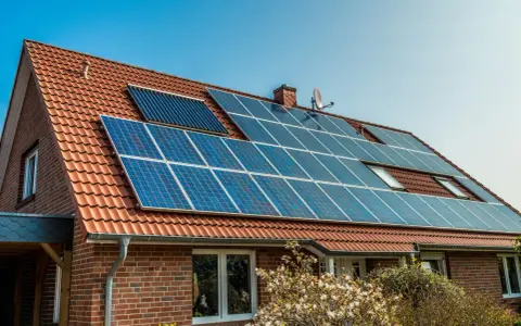 Dom z panelami fotowoltaicznymi na dachu. Nowe zasady dla inwestujących w zieloną energię.