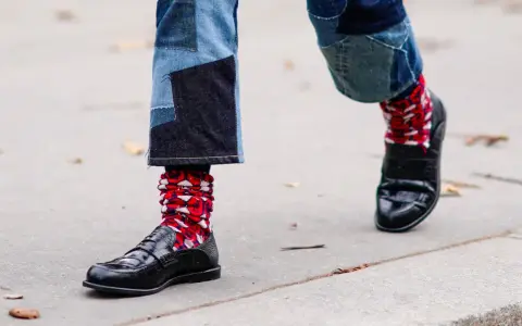 Pantaloni patchwork e scarpe eleganti con calzini rossi a fantasia, un look audace per sfidare le scarpe senza calze in inverno.