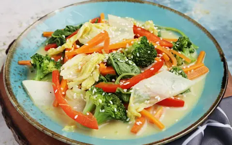 Buntes Gemüsegericht mit Chinakohl, Karotten, Brokkoli und Paprika in cremiger Sauce, bestreut mit Sesam. Leckere Chinakohl Rezepte!