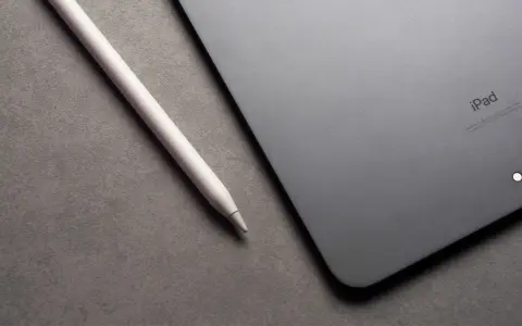Apple Pencil liegt neben einem iPad mit drei leuchtenden Punkten.