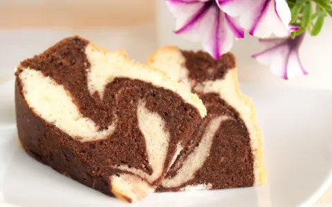 Zwei Stücke saftiger Marmorkuchen mit schöner Maserung, perfekt für ein gemütliches Kaffeetrinken. Dieses Marmorkuchen Rezept ist ein Klassiker.