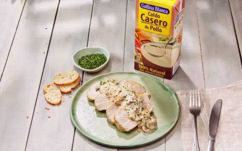 Lonchas de solomillo de pavo con salsa cremosa de champiñones, acompañadas de pan tostado y cebollino picado.