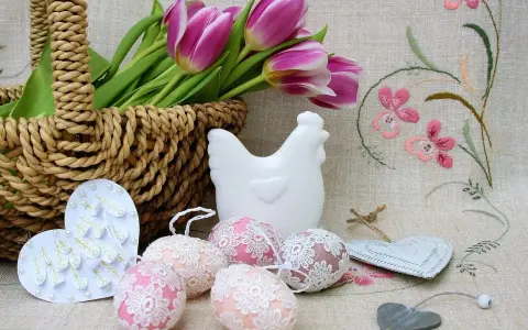 Wielkanocne dekoracje: koszyk z tulipanami, ceramiczna kurka, ozdobne jajka i serca.