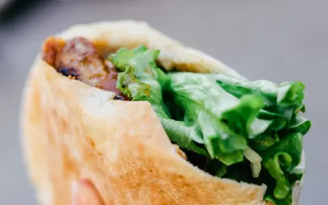 Kebab w bułce z mięsem i świeżą sałatą.