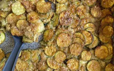 Fette di zucchine al forno semplici, dorate e croccanti, con una spolverata di parmigiano. Un contorno gustoso e facile da preparare.