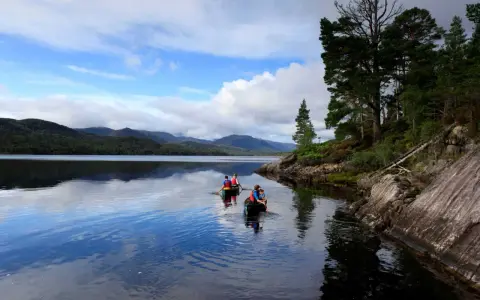 Zwei Kanus auf dem Loch Ness, umgeben von schottischen Highlands. Vielleicht sucht Nessie nach Gesellschaft?