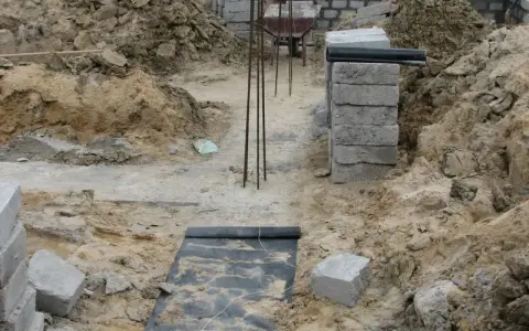 Budowa domu. Kopanie pod fundamenty, zbrojenie i pierwsze warstwy bloczków betonowych.
