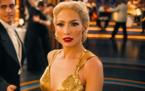 Jennifer Lopez i en glittrande guldig klänning på en dansgolv, en scen från filmer med Jennifer Lopez.