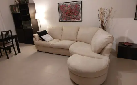 Divano angolare beige con pouf, un'idea su come rivestire un divano non sfoderabile per un look rinnovato.