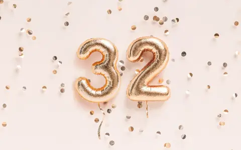 Złote balony z cyframi 3 i 2, otoczone konfetti. To już 32 tydzień ciąży, czas na świętowanie!