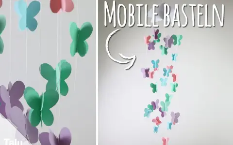 Bunte Schmetterlinge aus Papier hängen an Schnüren und bilden ein Mobile. Hier gibt es kostenlose mobile basteln vorlagen!