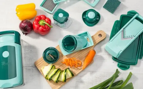 Ein nicer Dicer-Set mit verschiedenen Aufsätzen, Paprika, Zwiebel, Karotte und Zucchini. Perfekt für kreative Gemüsezubereitung.