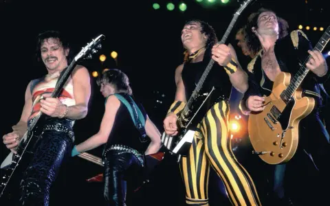 Le groupe Scorpion en pleine performance, des guitaristes aux looks audacieux, sur scène.