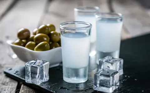Trzy kieliszki z mlecznym ouzo, kostki lodu i miseczka oliwek. Tak pije się ouzo, by poczuć smak Grecji.
