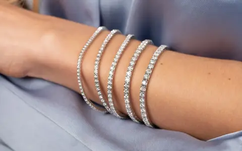 Bracciale tennis, un gioiello scintillante che ricorda la linea di un campo da gioco, indossato su un braccio.