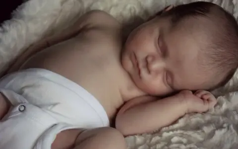 Słodki noworodek śpi spokojnie, jak wiele drzemek roczne dziecko. Otulony w miękkie futerko, wygląda na bardzo zrelaksowanego.