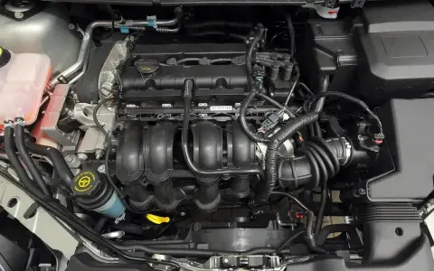 Silnik Ford Focus MK2, widok z góry. Widać kolektor dolotowy, zbiornik płynu wspomagania kierownicy i elementy układu chłodzenia.