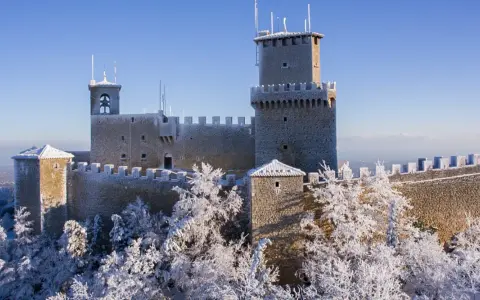Le tre torri di San Marino innevate, un magico **percorso 3 torri San Marino** sotto un cielo azzurro.