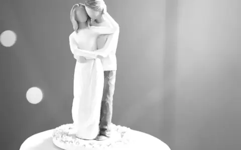 Figura de pareja abrazada, celebrando sus 20 años bodas de. Un símbolo de amor eterno sobre un pastel.