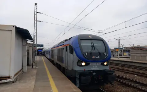 Lokomotywa PKP Intercity SU160-003 na torach kolejowych przy peronie.