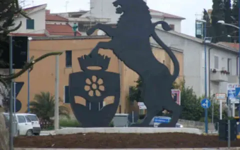 Leone rampante con stemma floreale, simbolo di Santa Margherita di Belice, domina la piazza.