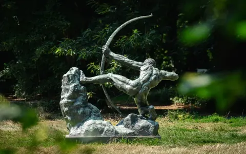 La sculpture de l'archer, une œuvre d'Antoine Bourdelle, se dresse fièrement dans un jardin verdoyant, capturant l'instant d'une tension parfaite.