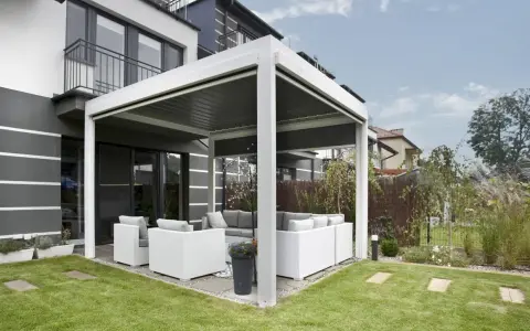 Une pergola moderne avec salon de jardin, offrant un espace extérieur confortable. C'est une définition pratique de pergola.