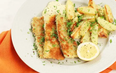 Krispigt friterad zucchini med pommes frites, en klick sås och en citronskiva.
