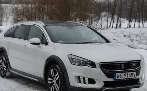 Biały Peugeot 508 RXH na śniegu, gotowy na zimowe wyzwania.