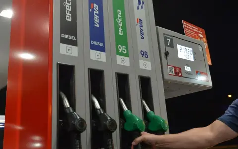 Dłoń sięga po dystrybutor z napisem "verva diesel" na stacji paliw. Obok widnieją inne rodzaje paliwa.