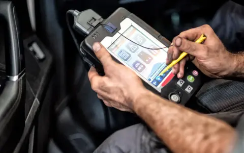 Mechanik używa zaawansowanego interfejsu diagnostycznego do analizy danych z samochodu.
