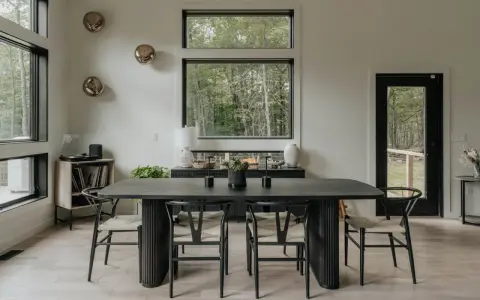 Elegante mesa negra y sillas de diseño para una perfecta decoracion comedores modernos. Ventanales con vistas al bosque.