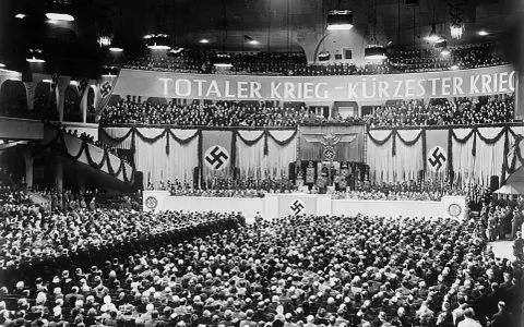 Große Menschenmenge im Sportpalast, die der Sportpalastrede zuhört. Banner verkündet "Totaler Krieg".