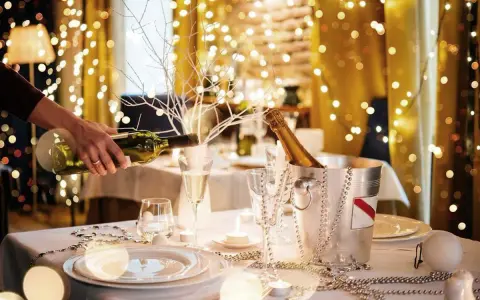 Mesa festiva con luces navideñas, champán y vino. Ideas para decorar un bar para Navidad con estilo y elegancia.