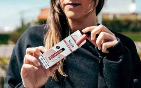 Una persona sostiene una caja de vapeador desechable Frumiist Zero sabor sandía.