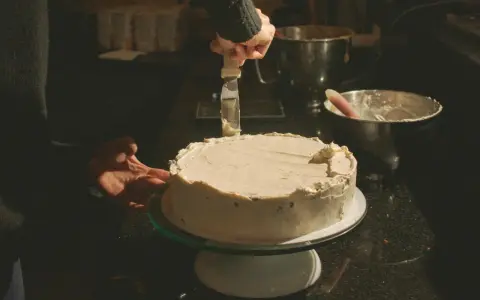 Ostatnie poprawki na torcie, którego kremowa polewa to pyszny tynk z mleka skondensowanego.
