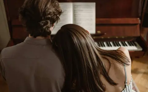Pareja compartiendo un momento íntimo junto a un piano, el verdadero **exclusividad significado** de la conexión.