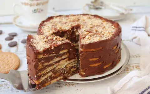 Deliciosa marquesa de chocolate, un postre casero con capas de galletas y crema de cacao, espolvoreada con frutos secos.