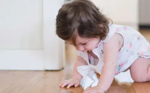 Kleines Baby krabbelt auf dem Boden. Bald ziehen sich Babys hoch und erkunden die Welt.
