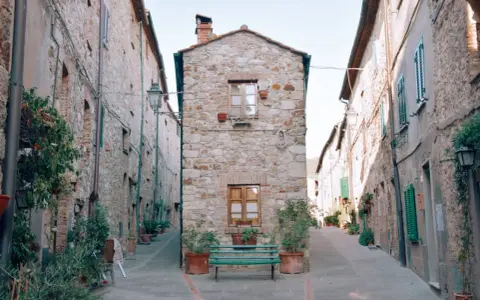 Un vicolo stretto con case in pietra e piante in vaso. Un invito a scoprire cosa vedere a Cecina, tra scorci pittoreschi e storia.