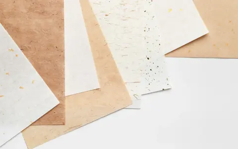 Różne rodzaje papieru, od jasnych po brązowe, z delikatnymi zdobieniami. Każdy papier to inna klasa papieru, idealna do twórczych projektów.