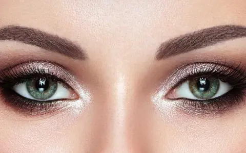 Ojos verdes deslumbrantes con un maquillaje ahumado y brillante, realzando su belleza natural.